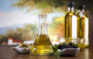 Foto de Botella de aceite de oliva y aceitunas en una mesa